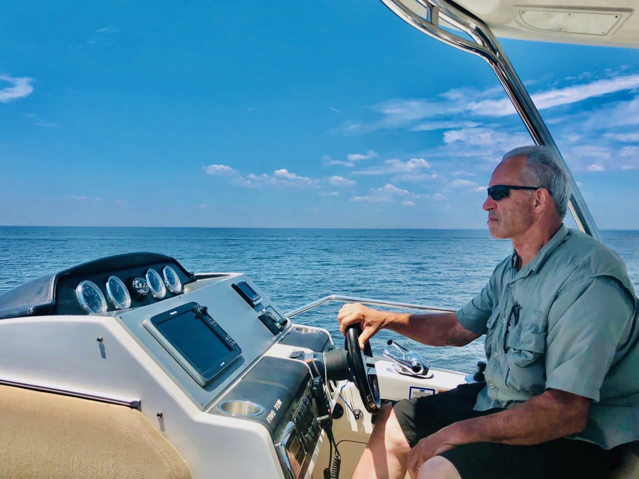 Captain teaching student how to steer and navigate at the helm